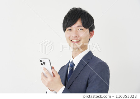Businessman using smartphone, white background, looking at camera 110353328