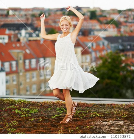 Portrait, dance and smile with a woman on a roof in her neighborhood for energy or freedom in summer. Music, movement and a happy young person in celebration of her holiday or vacation as a tourist 110353871