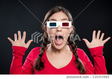 What a scare that was. a young woman wearing 3D glasses against a studio background. 110353985