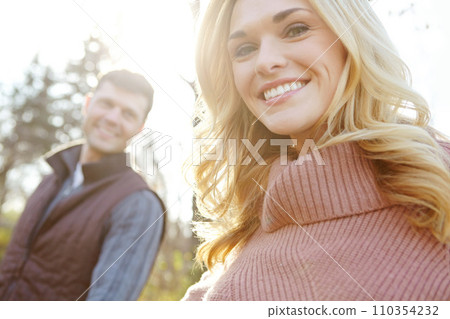 She enjoys nature walks. A happy and loving couple spending time out in the woods together. She enjoys nature walks. A happy and loving couple spending time out in the woods together. 110354232
