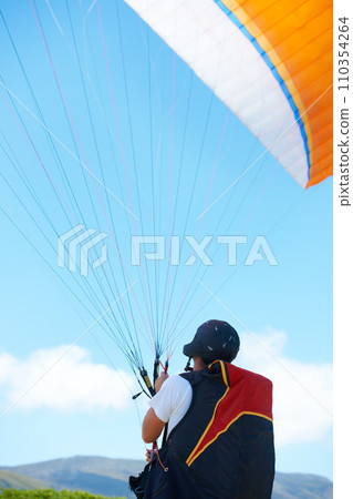 Nature, sport or man with parachute in preparation, launch or paragliding training for adventure in extreme exercise. Person, balance or strings for outdoor fun or fitness with helmet or safety gear 110354264