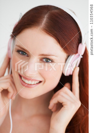 Smile, headphones and portrait of woman in a studio listening to music, playlist or album. Happy, excited and young female model from Canada streaming a song or radio isolated by white background. Smile, headphones and portrait of woman in a studio listening to music, playlist or album. Happy, excited and young female model from Canada streaming a song or radio isolated by white background. 110354568