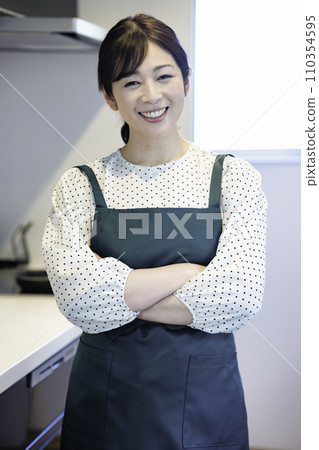 Middle-aged woman wearing an apron Middle-aged woman wearing an apron 110354595
