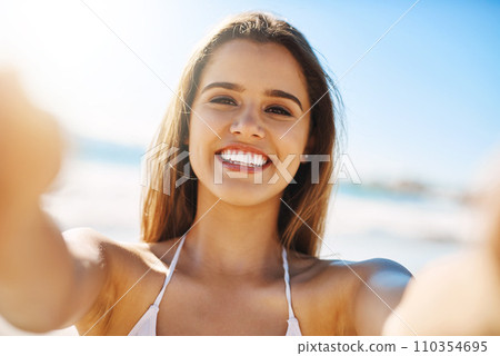 Im always happy when Im at the beach. Closeup shot of a beautiful young woman spending some time at the beach. 110354695