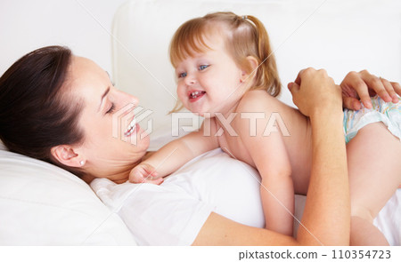 Baby, mother and laughing or hug on sofa with playing, relax and parenting in living room of home with security. Family, woman and girl child with happiness on couch in lounge for development or love 110354723
