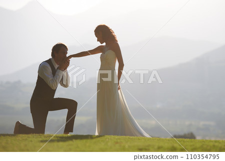 Couple, garden or kiss on hand in wedding for outdoor celebration, care or ceremony event. One knee, romantic groom or proud bride in bridal garment for commitment, love or marriage in park for space 110354795