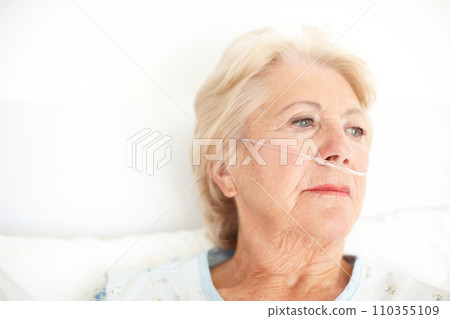 A heavy heart - Illness. Ailing senior woman wearing a nasal cannula looks out of her hospital window thoughtfully - Copyspace. 110355109