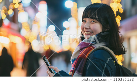 Smiling Japanese girl using mobile app on mobile phone Smiling Japanese girl using mobile app on mobile phone 110355158