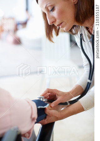 Clinical and professional examination. Closeup of a mature nurse checking the blood pressure of her patient. Clinical and professional examination. Closeup of a mature nurse checking the blood pressure of her patient. 110355187