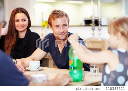 Family, woman or man with girl in dining room for relax, relationship or bonding at table in home with smile. Tea, parents or child with beverage for relaxation, happiness or peace in lounge of house Family, woman or man with girl in dining room for relax, relationship or bonding at table in home with smile. Tea, parents or child with beverage for relaxation, happiness or peace in lounge of house 110355321