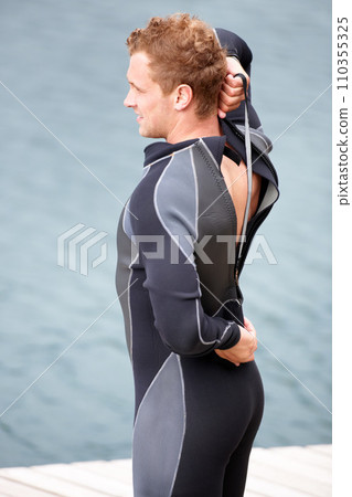 Man, ready and wetsuit at lake, outdoor and extreme sports for fitness, exercise and workout. Person, swimsuit and thinking by river, nature and safety with ideas, health and start summer training Man, ready and wetsuit at lake, outdoor and extreme sports for fitness, exercise and workout. Person, swimsuit and thinking by river, nature and safety with ideas, health and start summer training 110355325