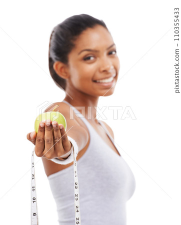 Apple, tape measure and lose weight with happy woman in white background or studio. Indian, model and portrait with healthy food for results in fitness, wellness and diet with nutrition and fruit 110355433