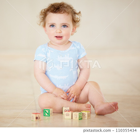 Baby, boy and blocks for building, floor and smile with development, learning or playful in family home. Infant child, toys and education for progress, growth or childhood with sitting, room or house 110355434