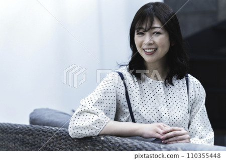 A middle-aged woman relaxing in the living room A middle-aged woman relaxing in the living room 110355448