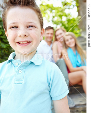 This is my family. Cute little boy with family sitting behind him while outdoors. 110355500