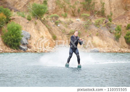 Nature, water ski and adventure, man on lake with outdoor fun, fitness and wave splash. Balance, extreme sports and person on river with freedom, speed and energy in surfing challenge, rope and spray Nature, water ski and adventure, man on lake with outdoor fun, fitness and wave splash. Balance, extreme sports and person on river with freedom, speed and energy in surfing challenge, rope and spray 110355505