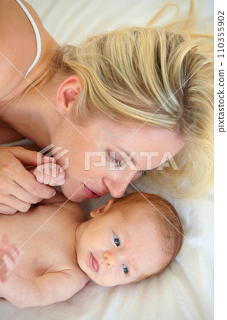 Relax, love and bed, mother and baby bonding, woman and kid lying in home together. Calm morning, mom and newborn in bedroom for rest, kiss and family wellness, comfort and child care from above. Relax, love and bed, mother and baby bonding, woman and kid lying in home together. Calm morning, mom and newborn in bedroom for rest, kiss and family wellness, comfort and child care from above. 110355902