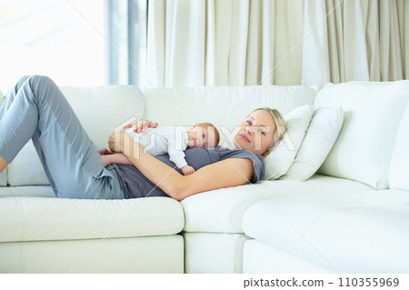 Relax, home and sofa, mother and baby bonding, woman and kid lying in living room together. Calm morning, mom and newborn on couch for rest, love and family security, comfort and child care in lounge 110355969
