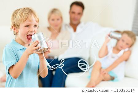 Home, family and children with tin can, game and fun in a living room, love and bonding together. Parents on a sofa, mother and father with kids, apartment or communication with smile, playing or joy Home, family and children with tin can, game and fun in a living room, love and bonding together. Parents on a sofa, mother and father with kids, apartment or communication with smile, playing or joy 110356114
