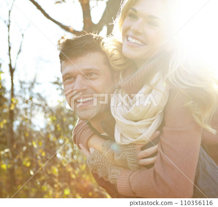 Having fun in the woods. A happy man piggybacking his girlfriend while spending time in the woods. Having fun in the woods. A happy man piggybacking his girlfriend while spending time in the woods. 110356116
