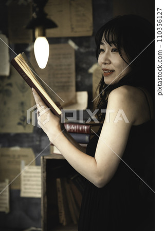 Young woman reading a book in a chic room 110356127