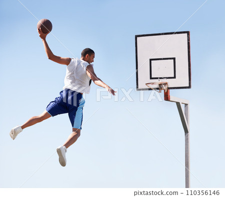 Man, basketball and dunk jump on outdoor court for scoring point, game challenge or athlete. Male person, hand and hoop strong for exercise fun or fitness training in summer, player for winner match Man, basketball and dunk jump on outdoor court for scoring point, game challenge or athlete. Male person, hand and hoop strong for exercise fun or fitness training in summer, player for winner match 110356146