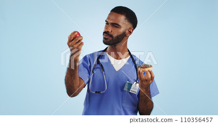 Doctor, apple and donut for health, diet or natural nutrition against a blue studio background. Man, medical nurse or surgeon with organic fruit and dessert in choice for wellness on mockup space 110356457