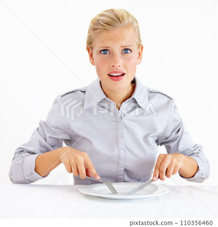 Confused, hungry and woman with empty plate in studio with bored, upset or shock face. Surprise, frustrated and portrait of female person from Australia with dish and cutlery by white background. 110356460