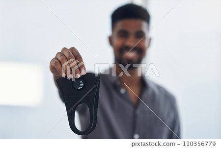 Its best for everyones safety and wellbeing. Portrait of a young businessman holding a face mask in an office. Its best for everyones safety and wellbeing. Portrait of a young businessman holding a face mask in an office. 110356779