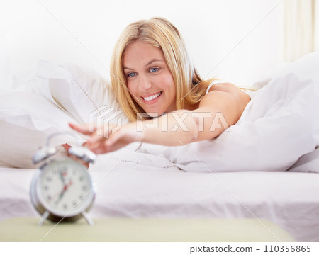 Happy woman, stop and alarm clock for time in bedroom with noise, sound or alert for waking up. Person, smile and excited expression on face for early morning by pressing, button and switch in home Happy woman, stop and alarm clock for time in bedroom with noise, sound or alert for waking up. Person, smile and excited expression on face for early morning by pressing, button and switch in home 110356865