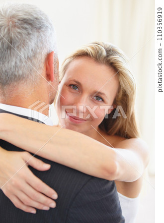 Portrait, love and a woman hugging her husband on their wedding day for romance or commitment. Face, smile and a bride embracing her groom for trust, safety or security during a marriage ceremony 110356919