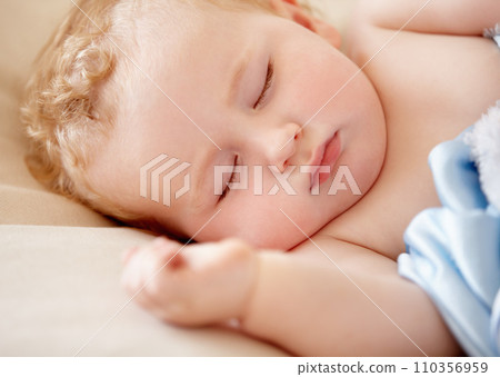 Sleeping, baby and infant closeup in bed with peace and rest in morning nap for growth or development. Child, sleep and face in bedroom, home or dreaming in crib with a blanket and sheet with comfort Sleeping, baby and infant closeup in bed with peace and rest in morning nap for growth or development. Child, sleep and face in bedroom, home or dreaming in crib with a blanket and sheet with comfort 110356959