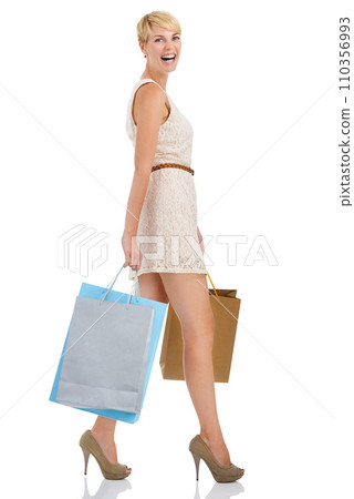 Happy woman, portrait and walking with shopping bags for fashion sale or purchase on a white studio background. Person, shopper or blonde smile with gift bag and heels for buying on mockup space 110356993