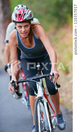 Cycling, fitness and portrait of woman on a bicycle in road for training, wellness or sports race. Health, exercise or face of lady athlete on a bike for morning cardio, workout or marathon challenge Cycling, fitness and portrait of woman on a bicycle in road for training, wellness or sports race. Health, exercise or face of lady athlete on a bike for morning cardio, workout or marathon challenge 110357017