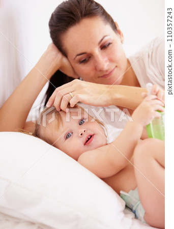 Baby, mother and portrait or smile on bed with bottle, relax and parenting in bedroom of home with security. Family, woman or girl kid with happiness in nursery for development, love or care in house Baby, mother and portrait or smile on bed with bottle, relax and parenting in bedroom of home with security. Family, woman or girl kid with happiness in nursery for development, love or care in house 110357243