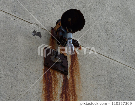 破舊的牆上亮著一個燈泡 110357369