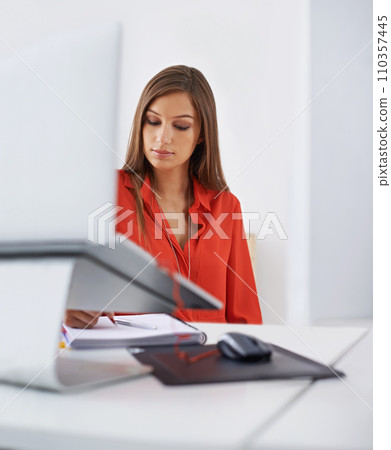 Theres no substitute for hardwork. a young woman busy writing at office desk. 110357445