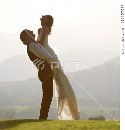 Groom lifting bride, hug and wedding outdoor, sunshine with love and commitment in marriage. Man, woman and happiness, celebration and social event with mockup space, romance and life partner Groom lifting bride, hug and wedding outdoor, sunshine with love and commitment in marriage. Man, woman and happiness, celebration and social event with mockup space, romance and life partner 110357485