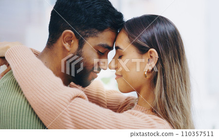 Happy couple, forehead and hug in home for love, support and relax for care, romance and gratitude for partner. Face of young man, interracial woman and calm together for date, loyalty or anniversary 110357511
