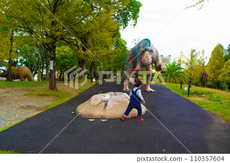 Back view of dinosaur and child at Nonhoi Park Back view of dinosaur and child at Nonhoi Park 110357604