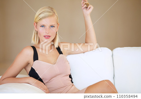 Woman, portrait and fashion on couch, attitude and elegant or stylish, confident and proud of clothing. Female person, relax and jewelry or accessories, beauty and makeup or face, sofa and sassy 110358494