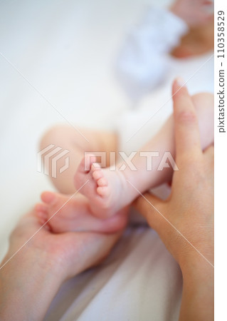 Baby, feet and hand for protection in bedroom with closeup for safety, security and care. Person, parent and bond with infant for love, support and hope for new life, development or future in home Baby, feet and hand for protection in bedroom with closeup for safety, security and care. Person, parent and bond with infant for love, support and hope for new life, development or future in home 110358529