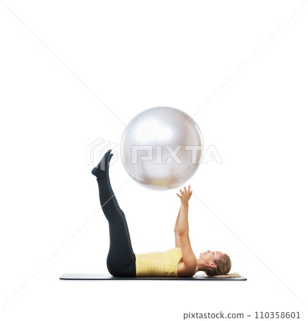Woman, ball or core balance on a white background space for workout, wellness or mobility exercise. Female athlete training, mat or fitness for mockup, stretching legs or body flexibility in studio 110358601