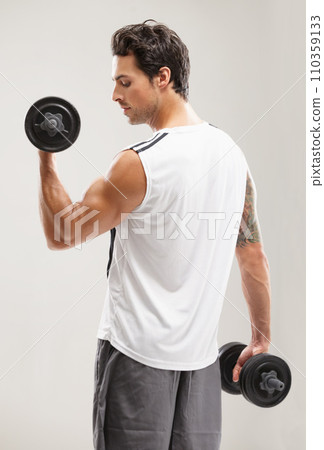 Fitness, back or man in dumbbell workout or training for wellness in studio on grey background. Strong male athlete, curl or bodybuilding exercise for power, body challenge or weights for performance Fitness, back or man in dumbbell workout or training for wellness in studio on grey background. Strong male athlete, curl or bodybuilding exercise for power, body challenge or weights for performance 110359133