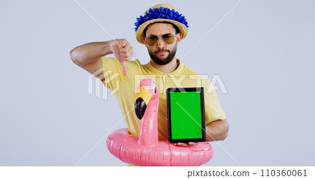 Green screen, tablet and man with thumbs down in studio for travel agency, review or service feedback on grey background. Digital, space and sad male traveler with emoji vote for app disappointment 110360061
