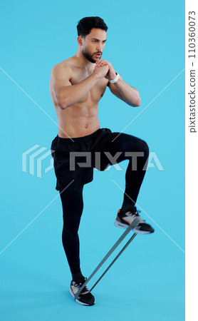 Man, legs and resistance band in fitness, workout or training against a blue studio background. Male person, athlete or serious model with straps for cardio exercise, endurance or stamina on mockup Man, legs and resistance band in fitness, workout or training against a blue studio background. Male person, athlete or serious model with straps for cardio exercise, endurance or stamina on mockup 110360073