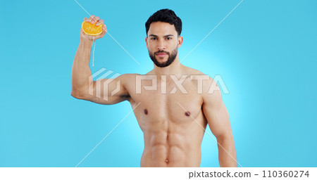 Orange, splash and portrait of man in studio for vitamin C, natural cosmetics or healthy diet on blue background. Fruit, squeeze or model face with citrus, juice or skin detox, wellness or nutrition Orange, splash and portrait of man in studio for vitamin C, natural cosmetics or healthy diet on blue background. Fruit, squeeze or model face with citrus, juice or skin detox, wellness or nutrition 110360274