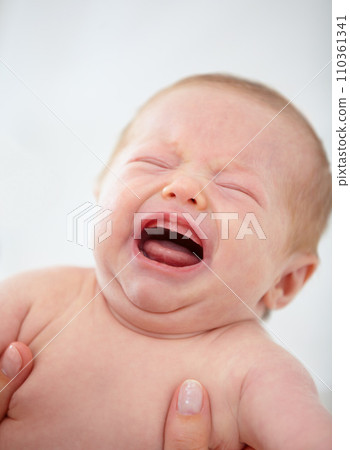 Closeup, baby and crying for upset in home for pain, unhappy or sadness with mother. Woman, hand and holding of infant for bath time, diaper or change in nursery for hygiene, health or cleanliness Closeup, baby and crying for upset in home for pain, unhappy or sadness with mother. Woman, hand and holding of infant for bath time, diaper or change in nursery for hygiene, health or cleanliness 110361341