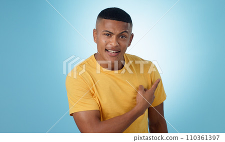 Pointing, question and portrait of man in a studio with mockup for marketing, advertising or promotion. Confused, thinking and young male person with a show hand gesture isolated by blue background. 110361397