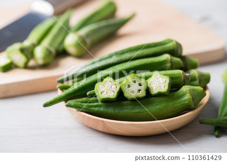 Green okra in wooden bowl prepare for cooking, Organic vegetables Green okra in wooden bowl prepare for cooking, Organic vegetables 110361429
